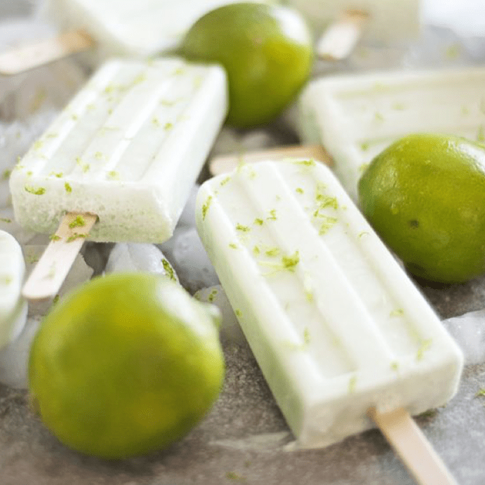 coconut and lime ice poles surrounded by fresh limes