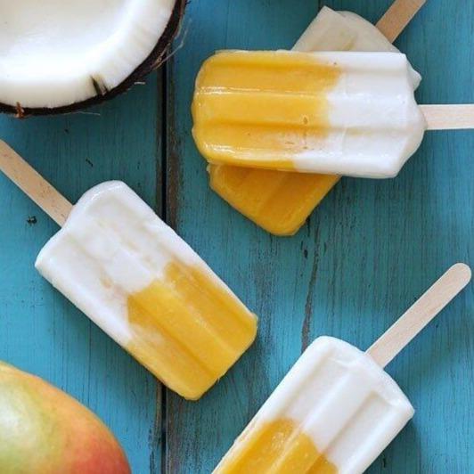 coconut and mango ice poles surounded by fresh mango and a coconut