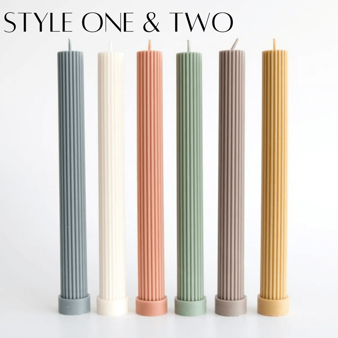 column pillar candles in various colours standing in a row on a white background