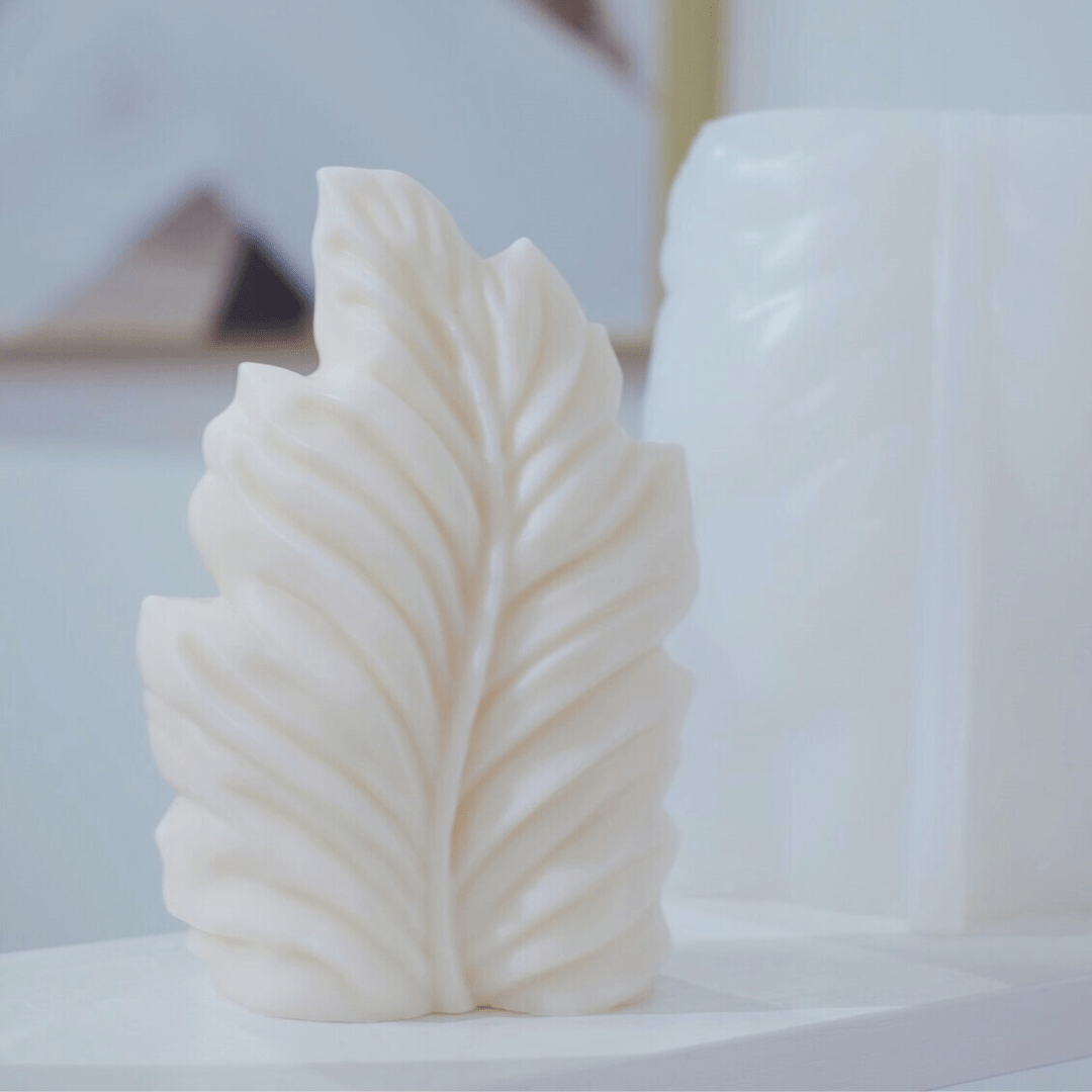palm leaf shaped candle mould in white wax with silicone mould in background