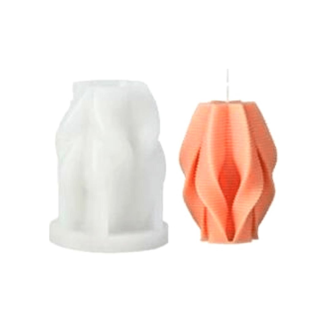 orange pleated pillar candle in orange wax sitting next to silicone mould with white background