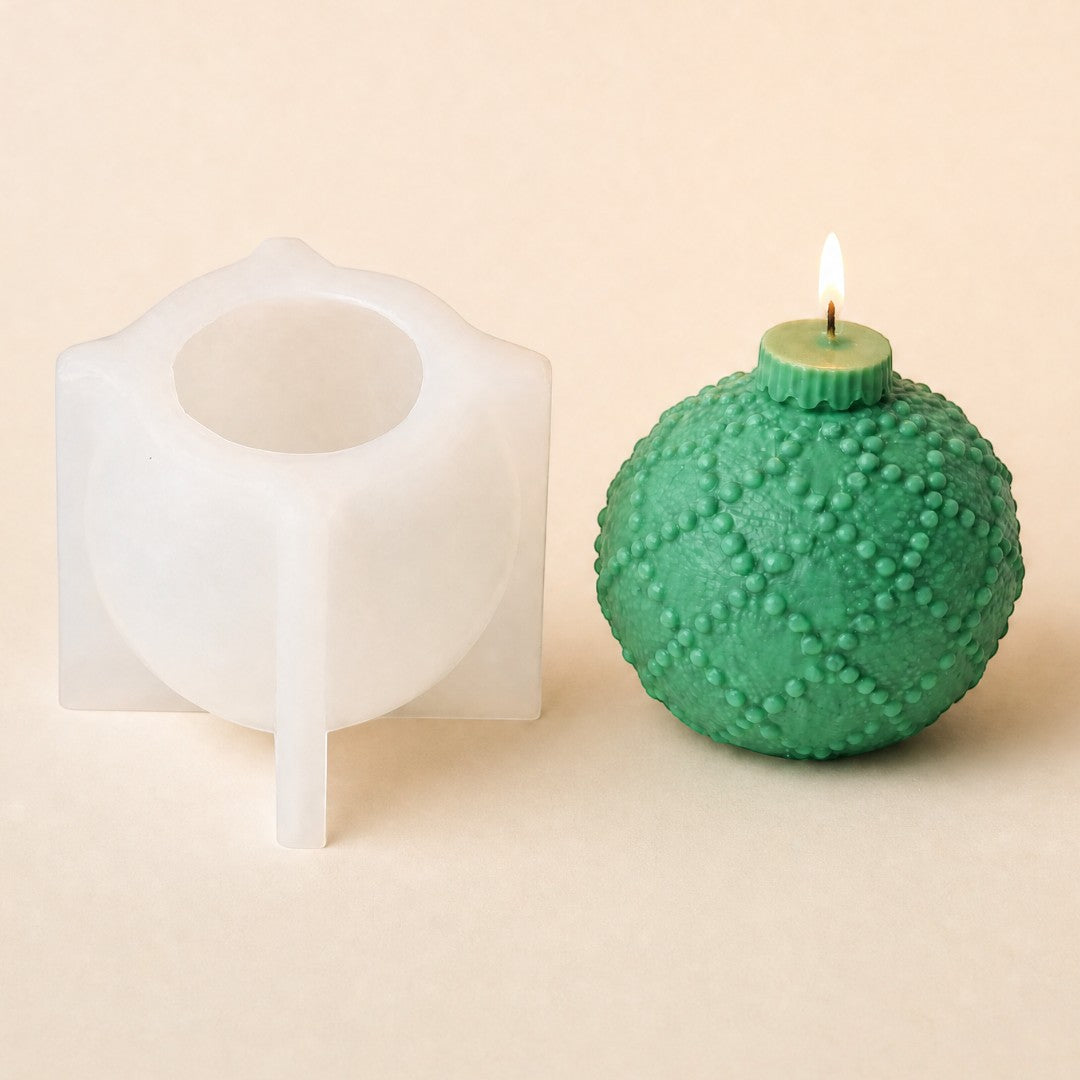 Pure Candle Supplies Melbourne silicone bauble mould next to a green textured Christmas bauble candle with a lit wick