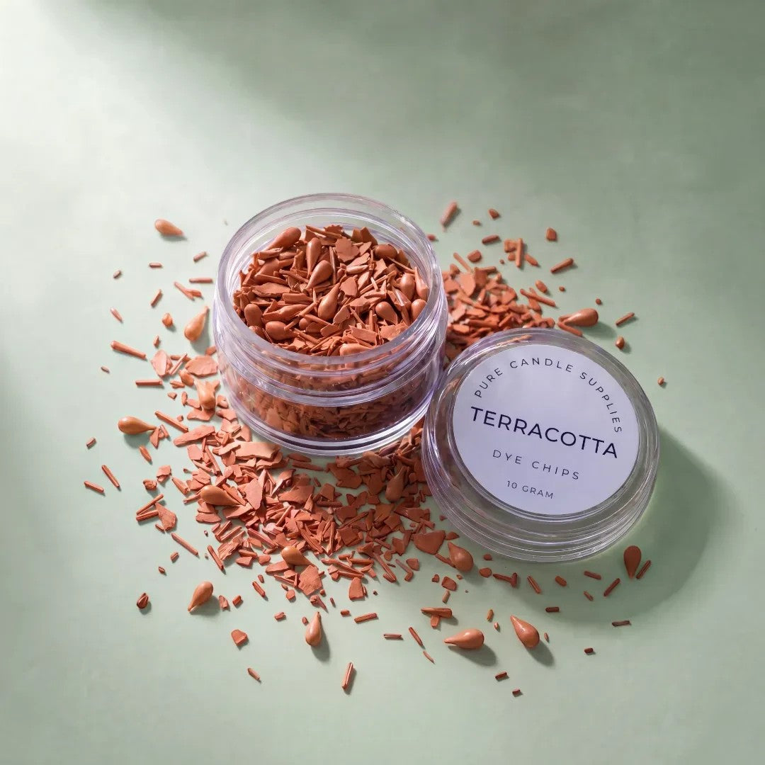 Pure Candle Supplies Melbourne terracotta dye chips in a small clear jar for candle making on a green background