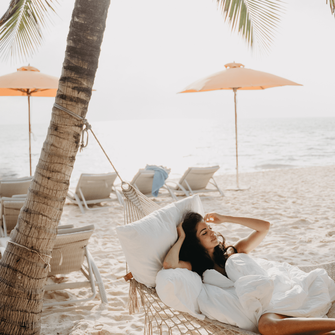 lady in hammock on the beach with fresh linen comfroter and pillow