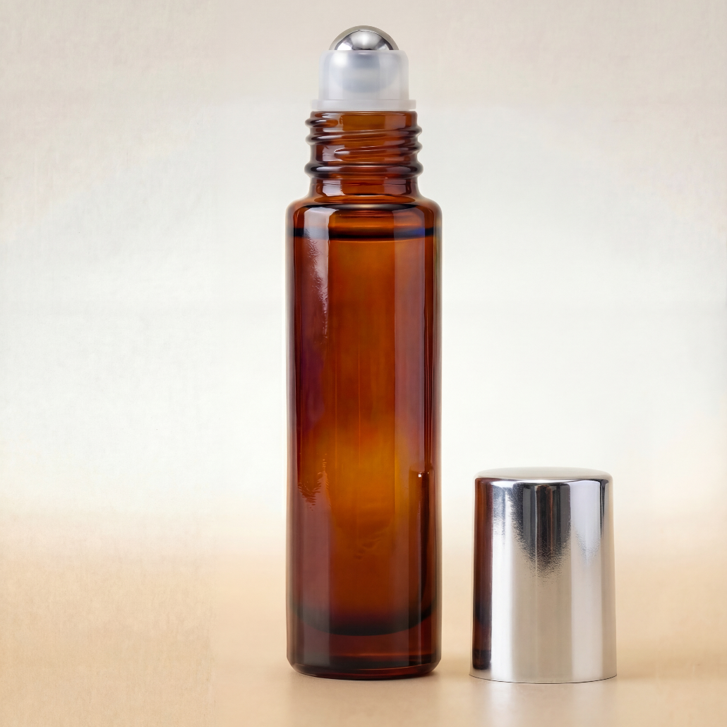 Amber glass roller bottle with silver cap on a beige background