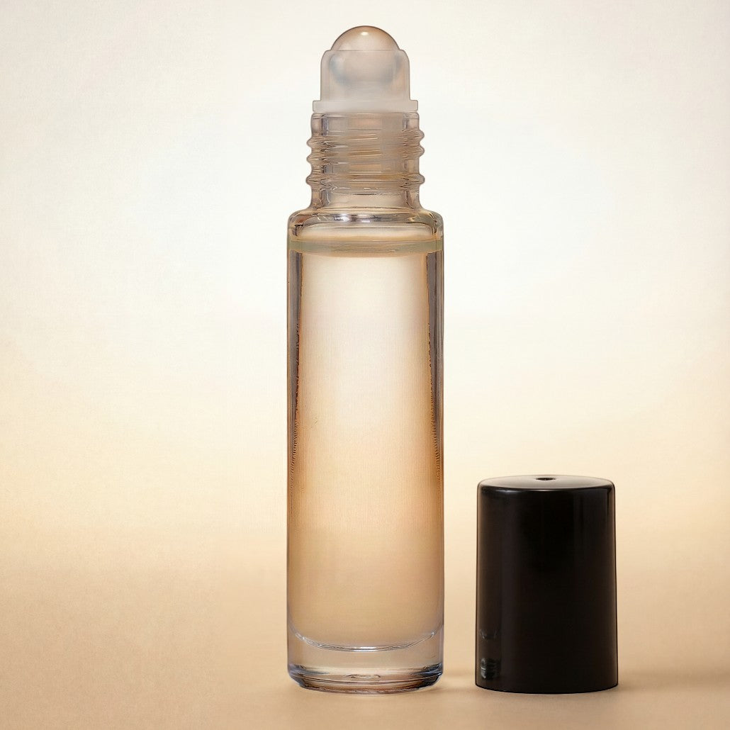 Clear glass roller bottle with black cap on a beige background