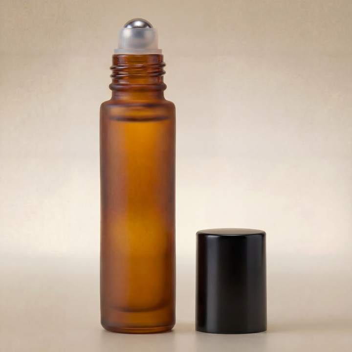Amber glass roller bottle with silver cap on a beige background