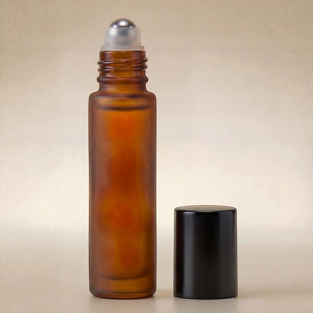 Amber glass roller bottle with silver cap on a beige background