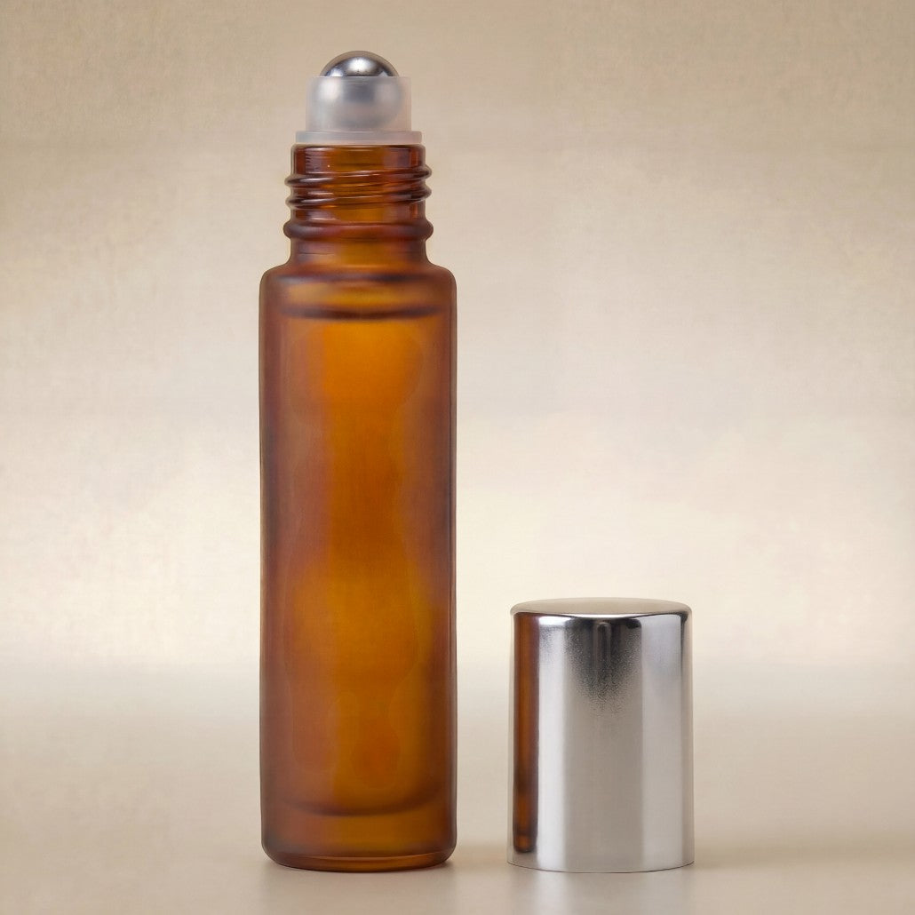 Amber glass roller bottle with silver cap on a beige background