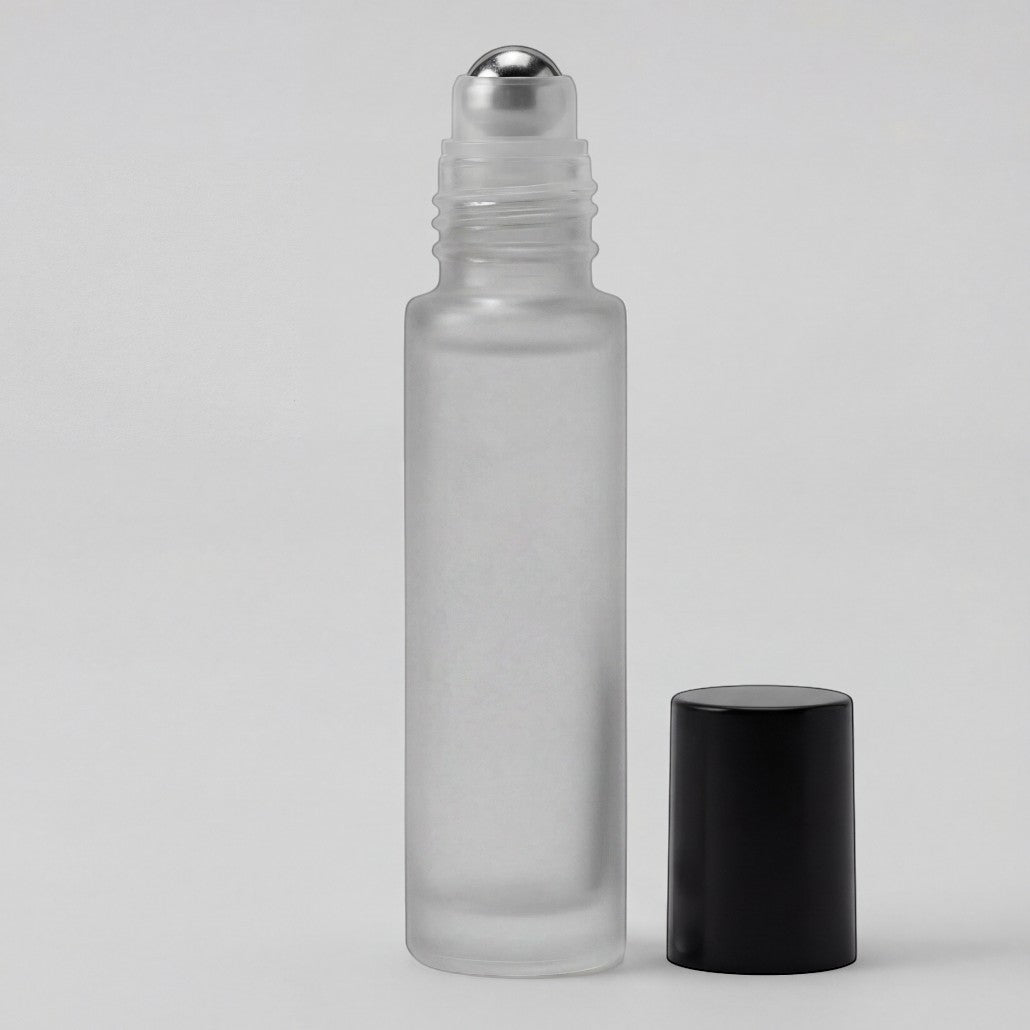 Clear glass roller bottle with silver cap and black cap on a light gray background