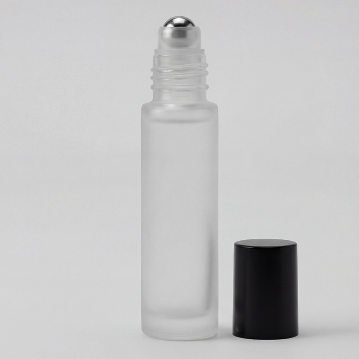 Clear glass roller bottle with silver cap and black cap on a light gray background