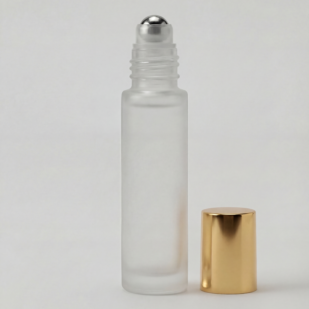 Glass roller bottle with silver cap and gold base on a light gray background