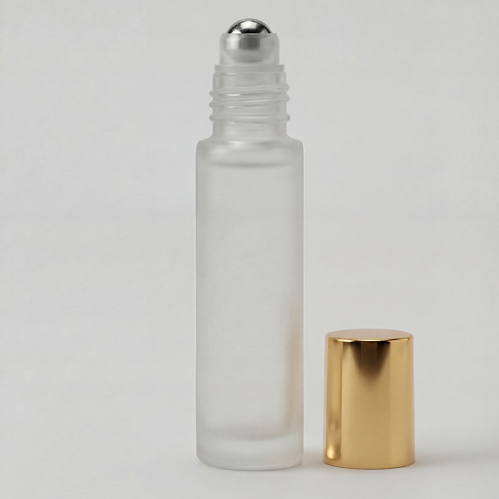 Glass roller bottle with silver cap and gold base on a light gray background