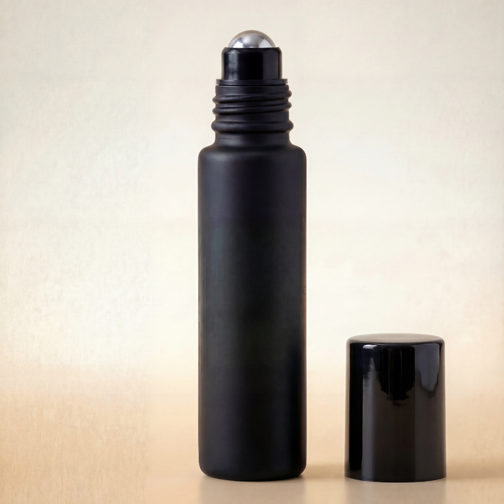 Black roller bottle with silver cap on a beige background