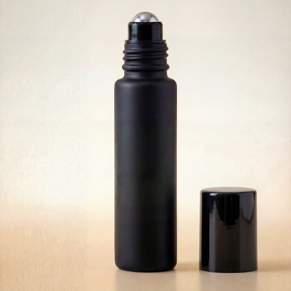 Black roller bottle with silver cap on a beige background