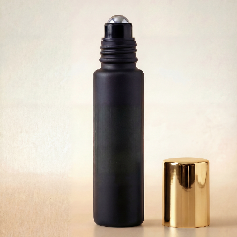 Black roller bottle with gold cap on a beige background