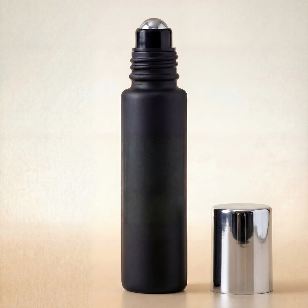 Black roller bottle with silver cap on a beige background