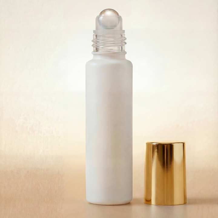 White rollerball bottle with gold cap on a beige background