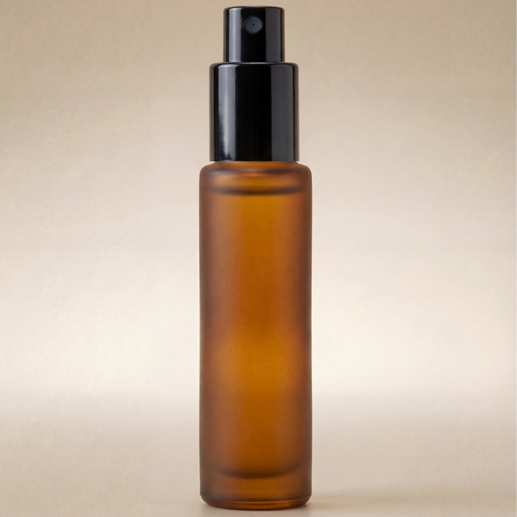 Amber glass spray bottle with black cap on a beige background