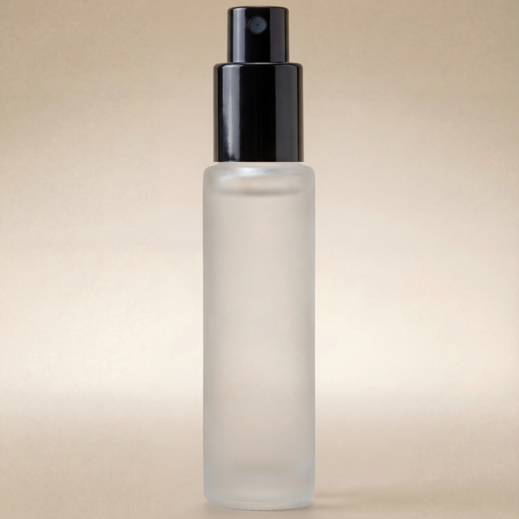 Clear glass bottle with black spray nozzle on a beige background