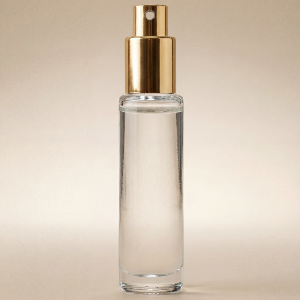 Clear glass bottle with gold cap on a beige background