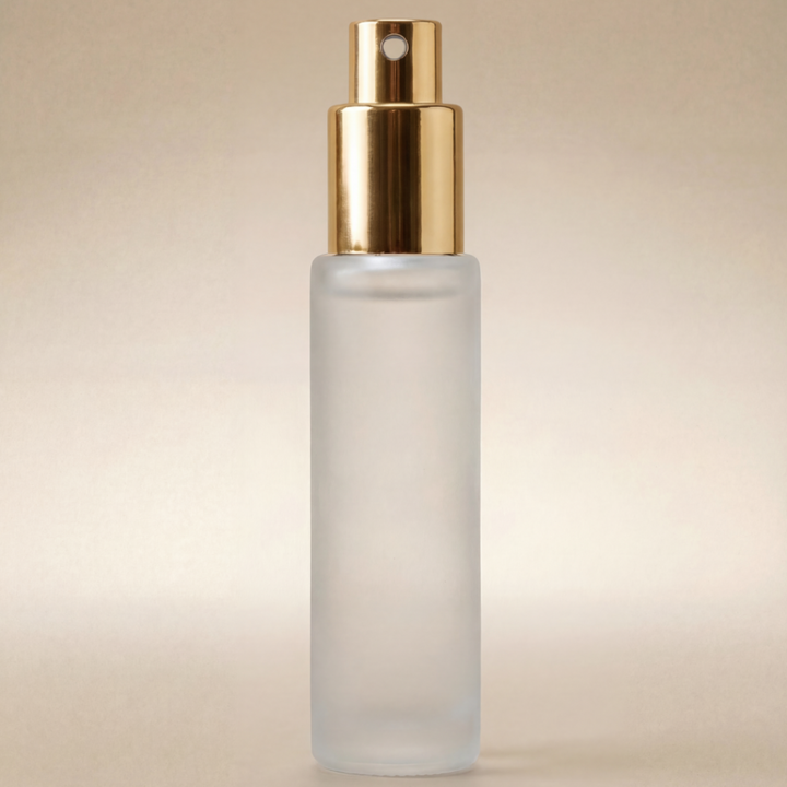 Frosted spray bottle with gold cap on a beige background