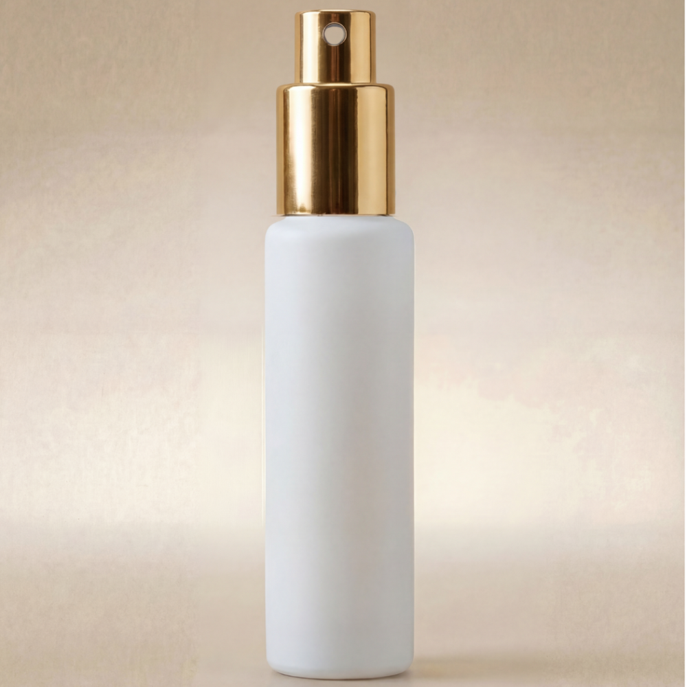 White spray bottle with gold nozzle on a beige background