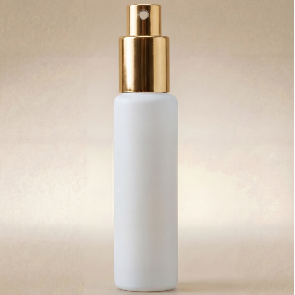 White spray bottle with gold nozzle on a beige background