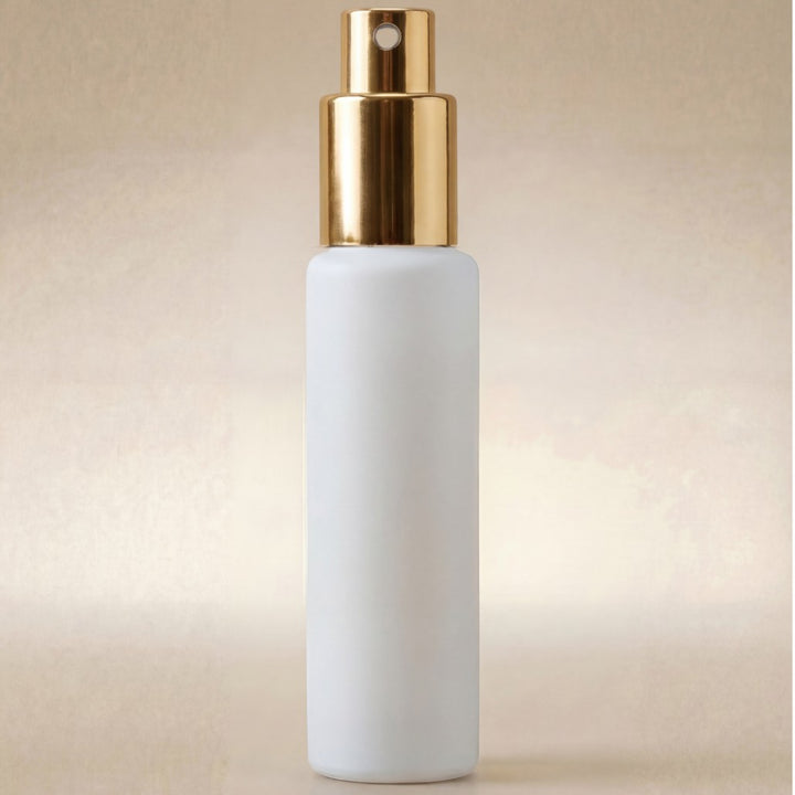 White spray bottle with gold nozzle on a beige background