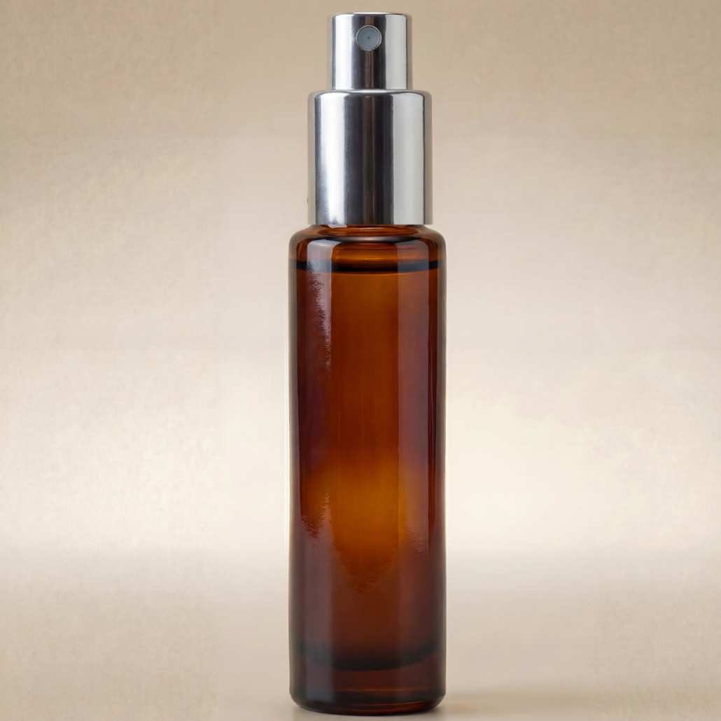 Amber glass spray bottle with silver nozzle on a beige background