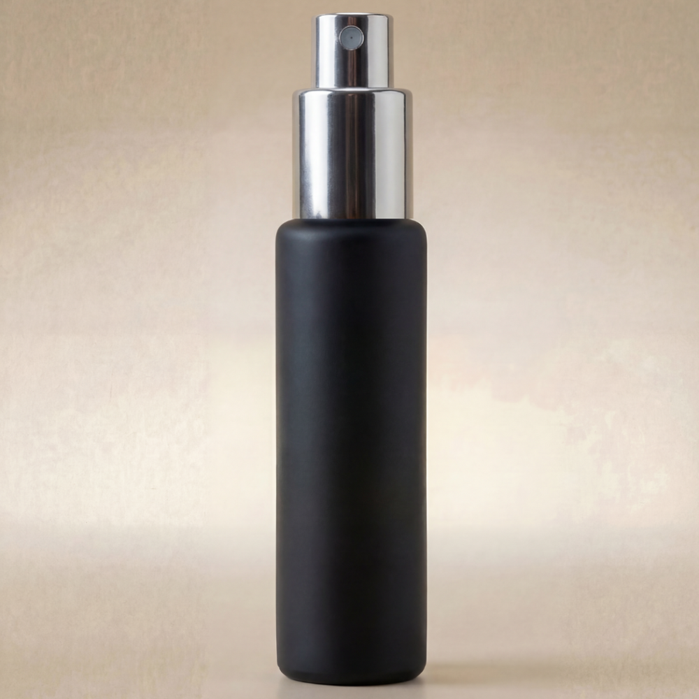 Black spray bottle with silver nozzle on a beige background