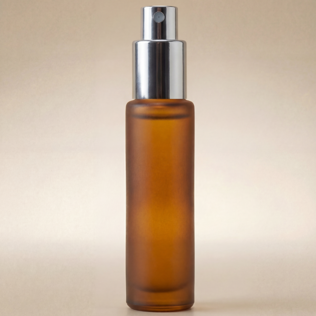Amber glass spray bottle with silver nozzle on a beige background