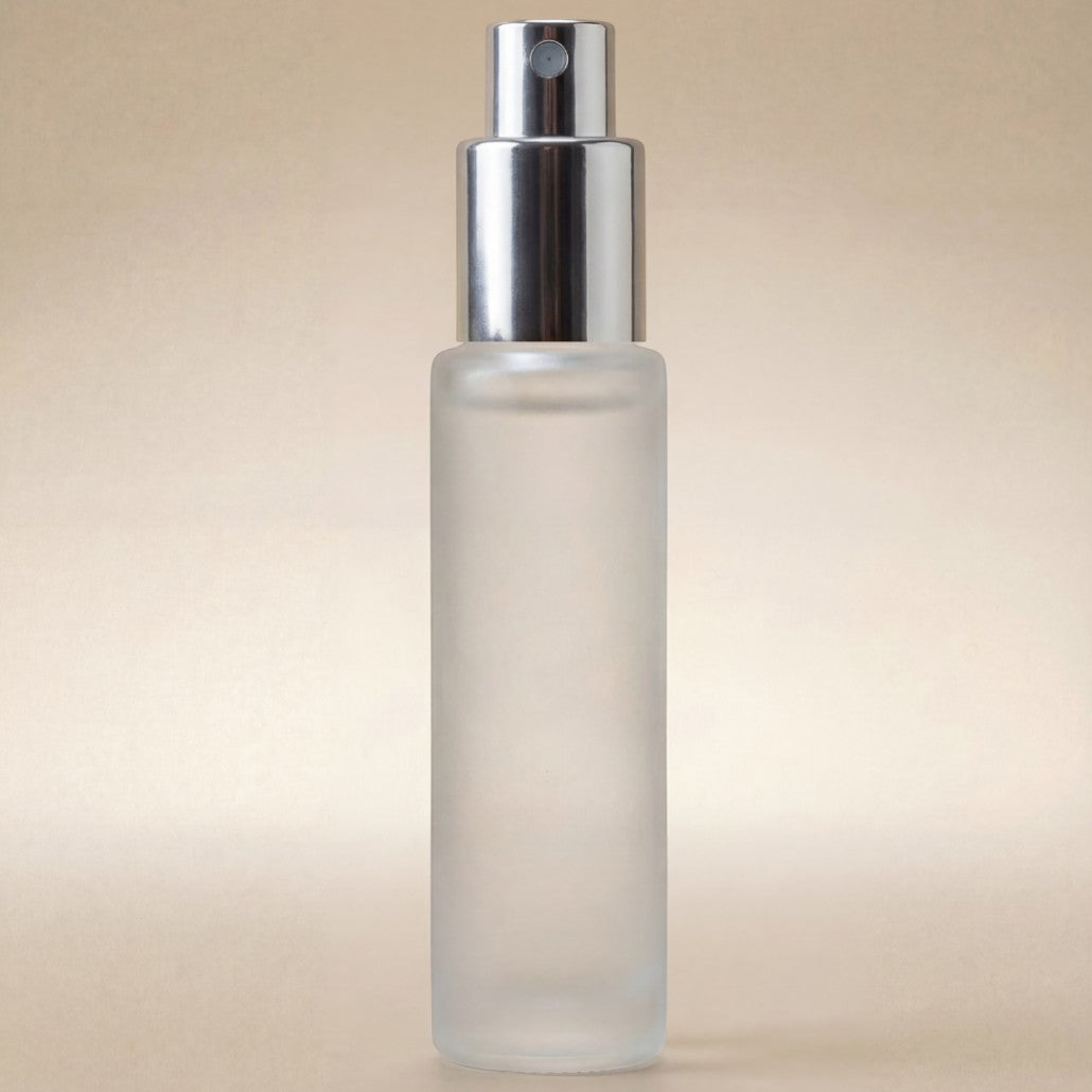 Frosted spray bottle with silver nozzle on a beige background