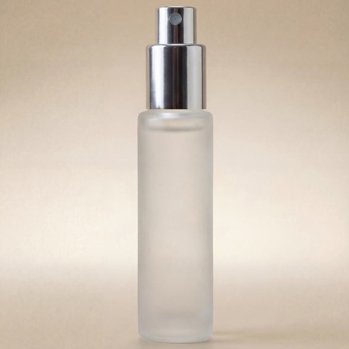Frosted spray bottle with silver nozzle on a beige background