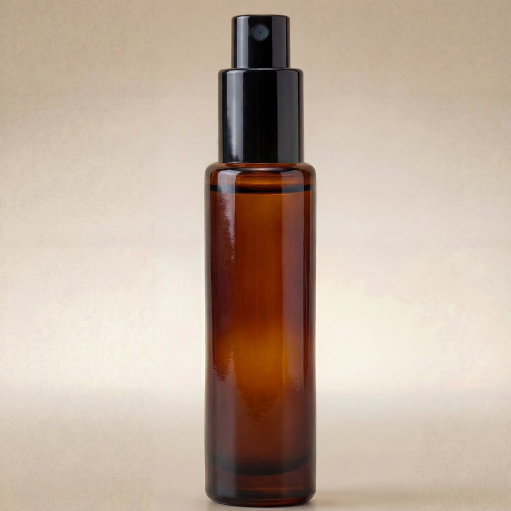 Amber glass spray bottle with black cap on a beige background