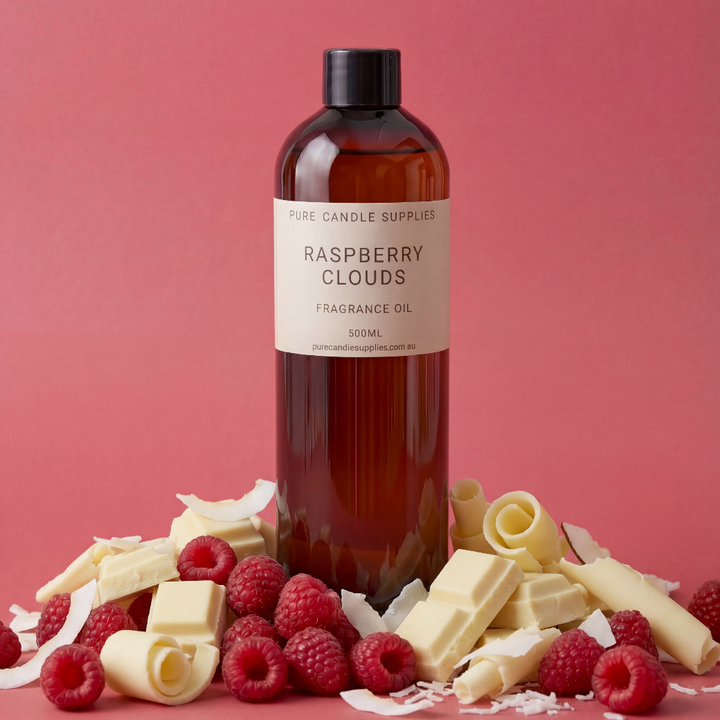 Bottle of Raspberry Clouds fragrance oil with raspberries and white chocolate on a pink background