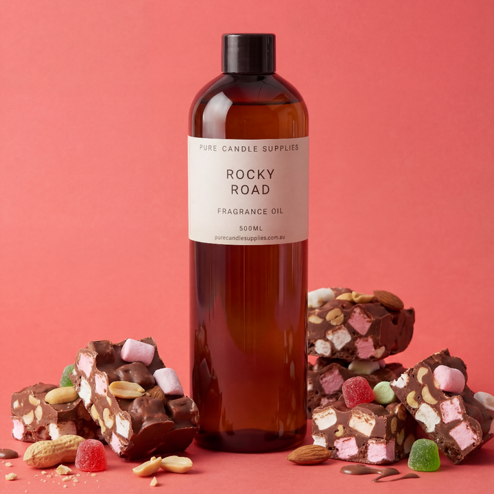 Bottle of Rocky Road fragrance oil with rocky road candy on a pink background