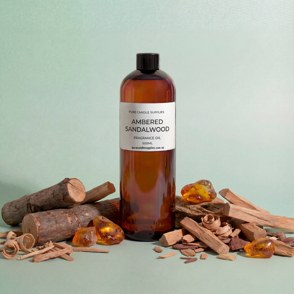 Bottle of ambered sandalwood fragrance oil with sandalwood pieces on a light green background