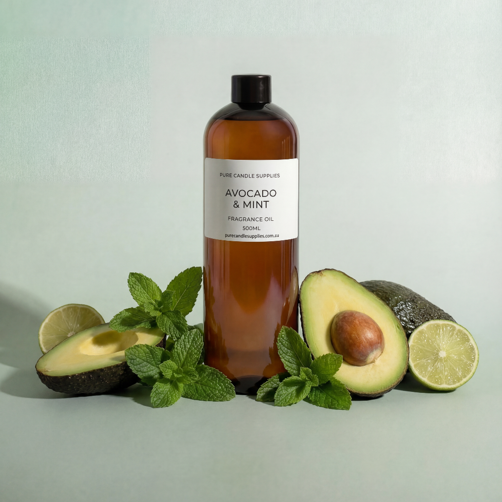 Bottle of avocado and mint fragrance oil with avocados, lime, and mint leaves on a light green background