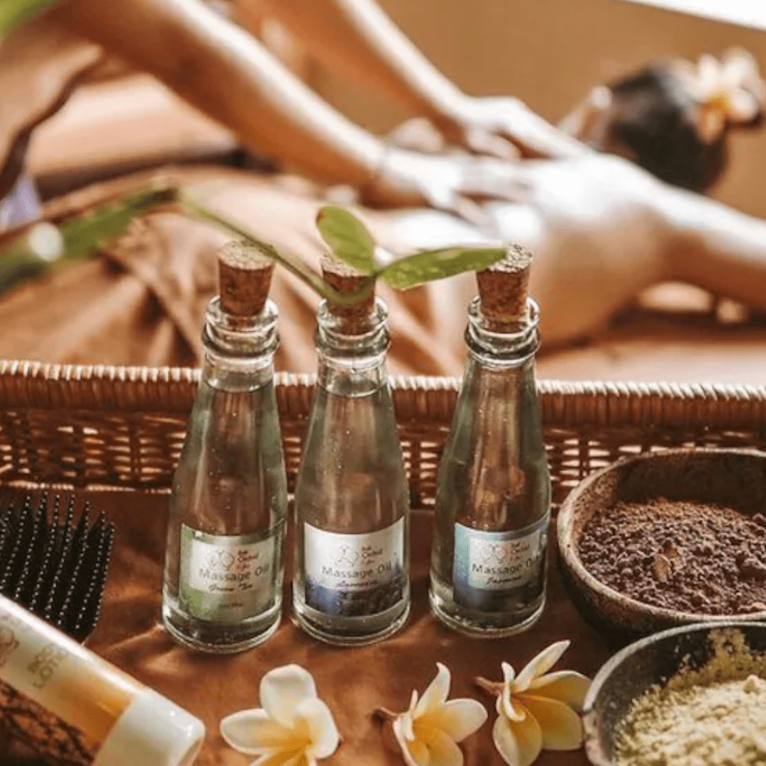 oils and spices on wooden tray in front of lady being massaged