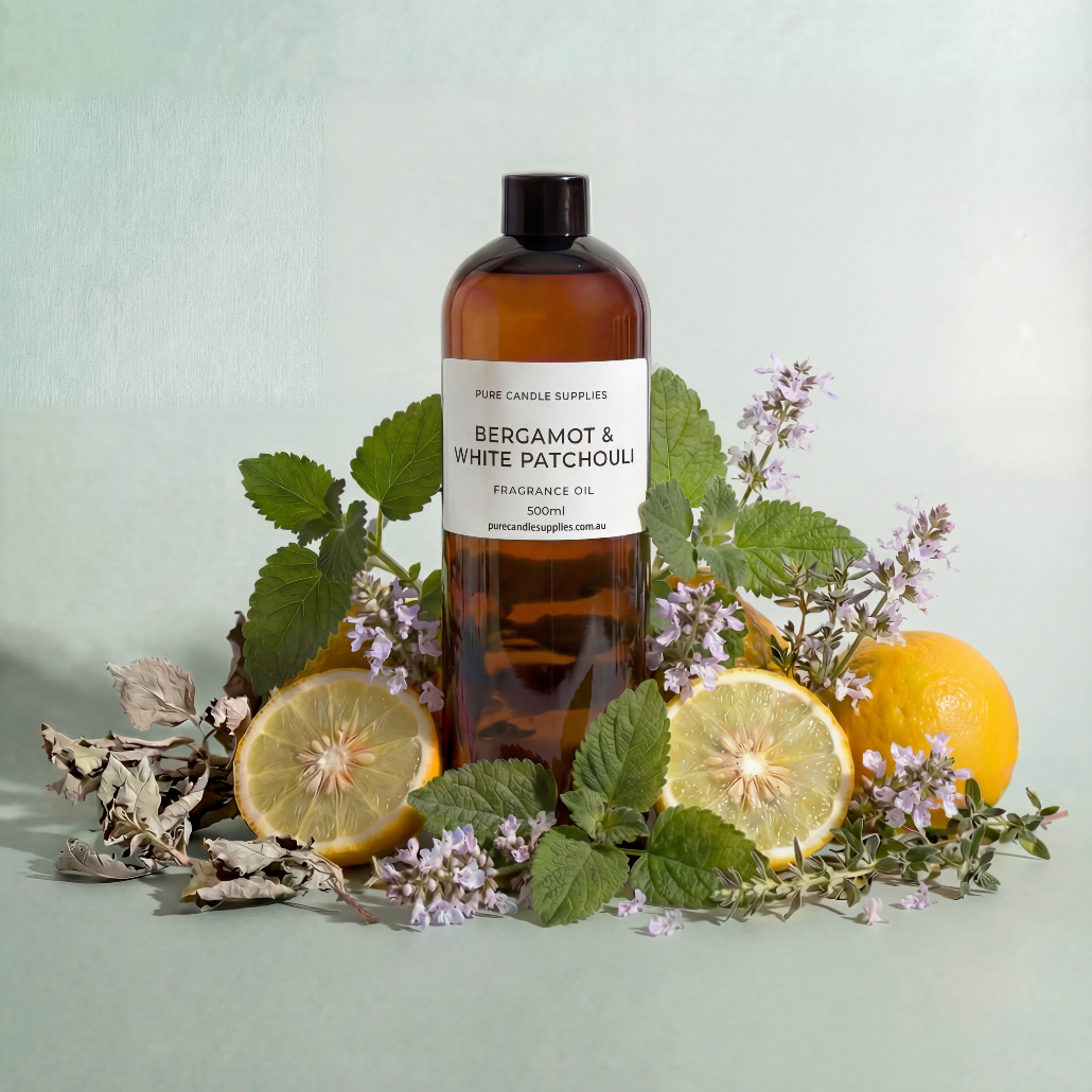 Bottle of Bergamot & White Patchouli fragrance oil with lemons and herbs on a light green background