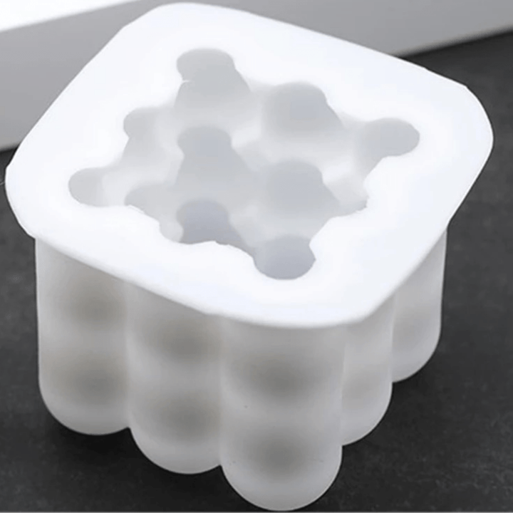 single cavity bubble cube candle mould in white silicone on a black and white background