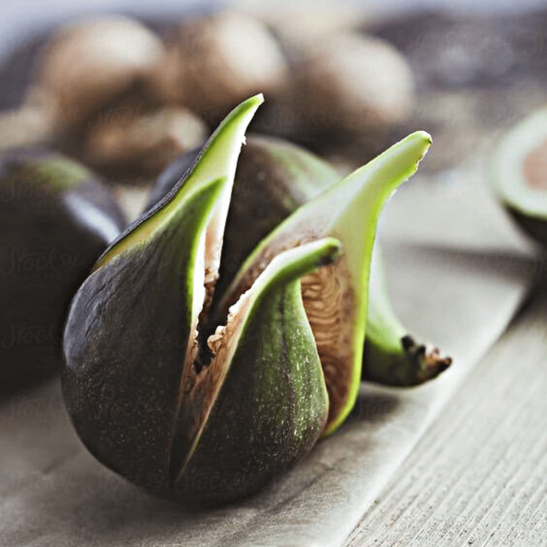 Fig resting on wooden board, slightly blooming