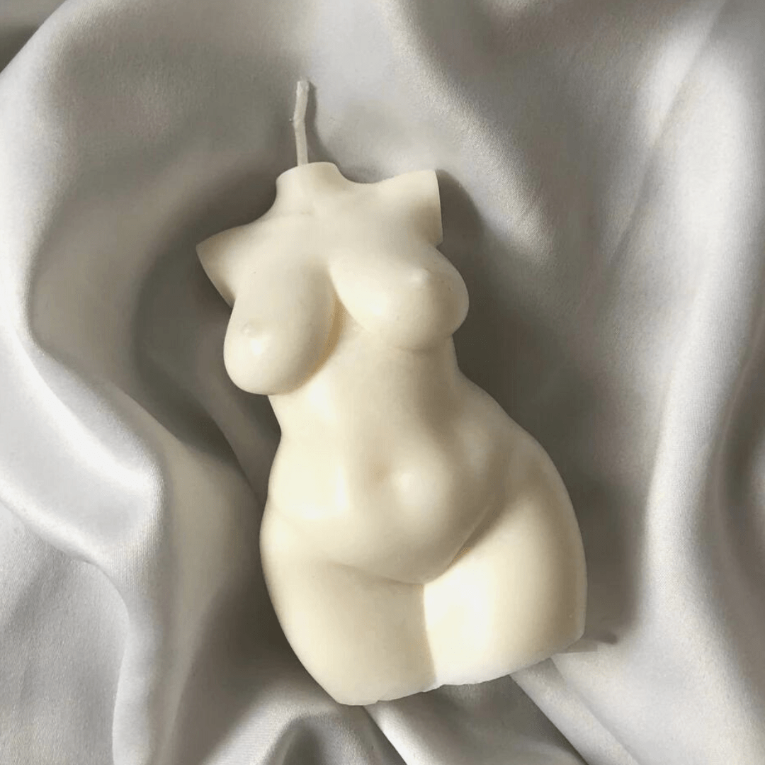 busty female body candle with wick in creamy colour on silky silver background