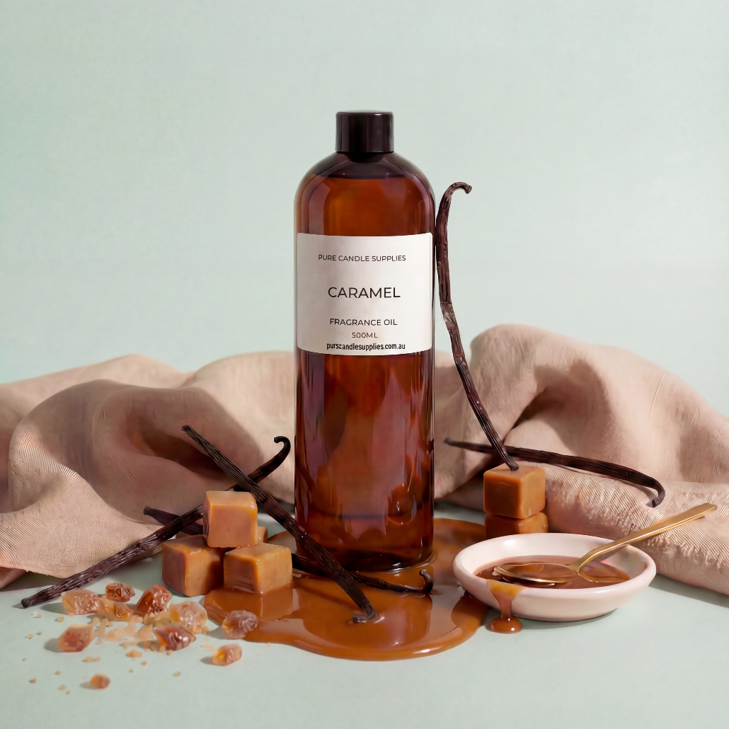 Bottle of caramel fragrance oil with vanilla beans and caramel pieces on a light background