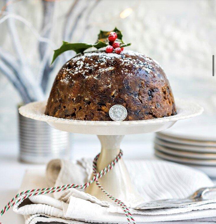 Christmas Pudding on top of tiered plate with holly on top