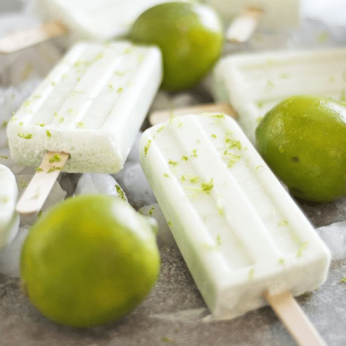 coconut and lime ice poles  surrounded by fresh limes