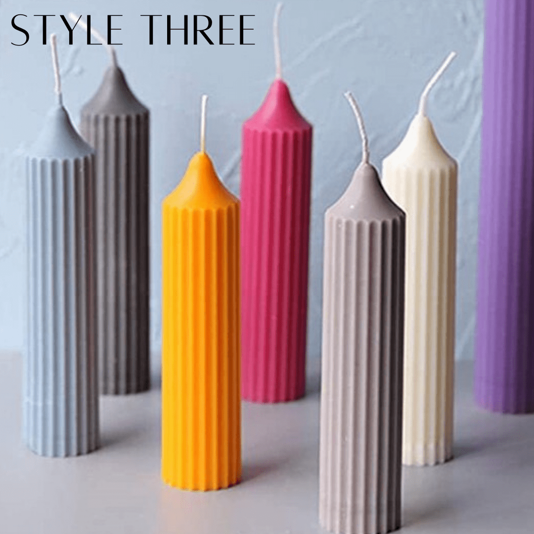 column pillar candles with pointed tip in various colours on a grey background