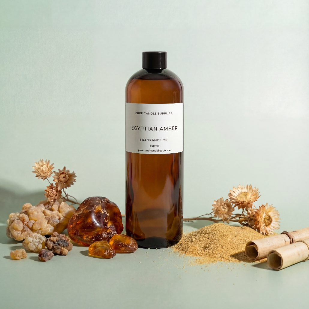 Brown bottle of Egyptian Amber fragrance oil with amber pieces and flowers on a light green background