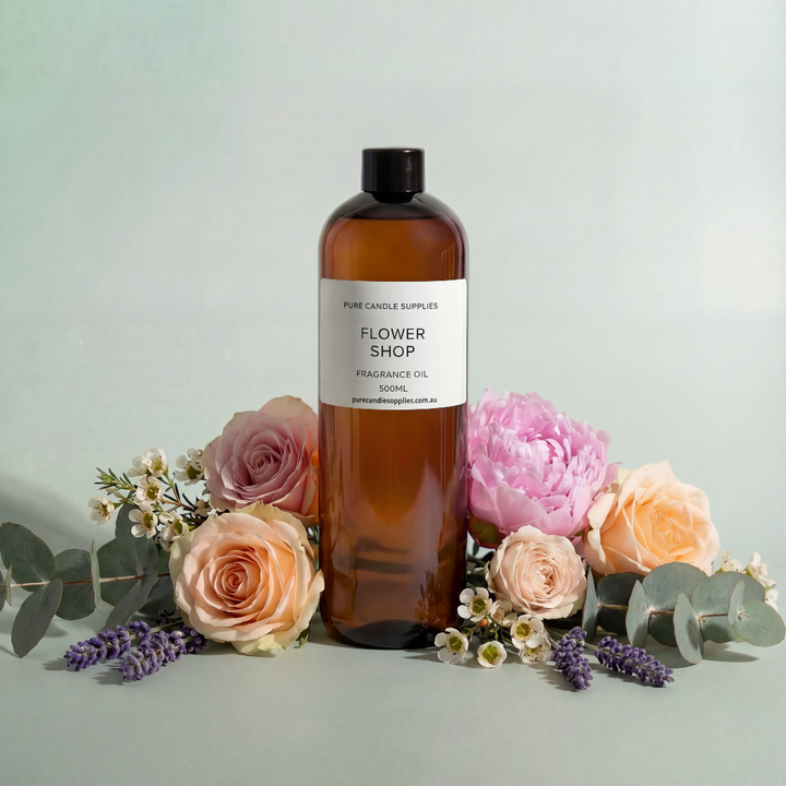 Bottle of 'Flower Shop' fragrance oil with flowers on a light background